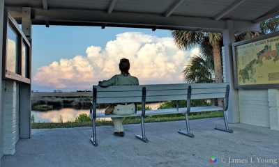 Visitor watches thunderstorm from bench near lighthouse. (6/7/2015) - St. Marks National Wildlife Refuge.